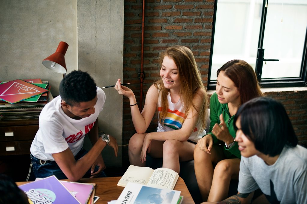 A group of young people sitting around a table working on schoolwork